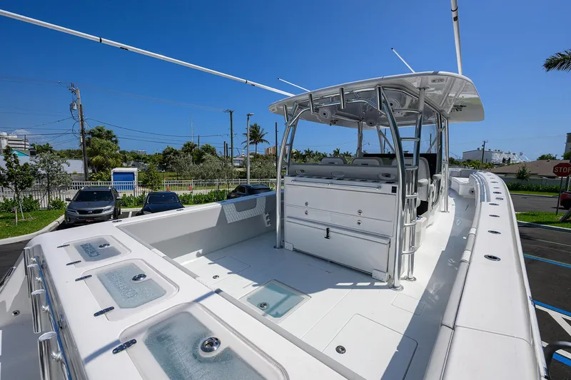 Slide: The Image of 2025 Contender 44ST boat with spacious deck and modern design under clear blue sky. - 27