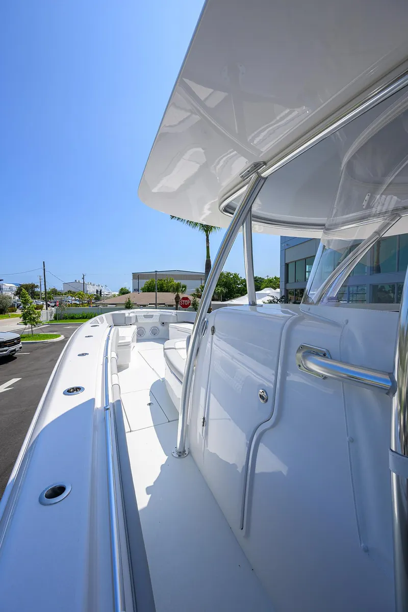 Slide: The Image of 2025 Contender 44ST boat, sleek design, white exterior, sunny day, marina background. - 3