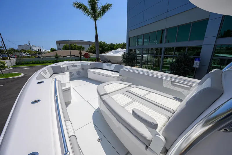 Slide: The Image of 2025 Contender 44ST boat with spacious seating and modern design, docked near a building. - 4