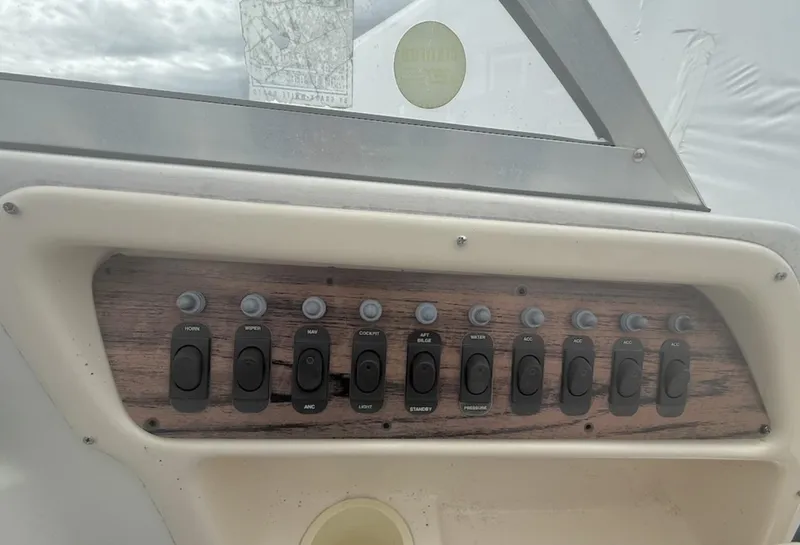 Slide: The Image of Control panel of 2000 Grady-White Adventure 208 boat with multiple switches. - 16