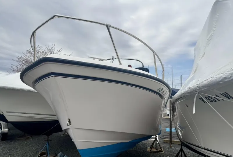 Slide: The Image of 2000 Grady-White Adventure 208 boat on stands, with blue hull and white deck. - 2