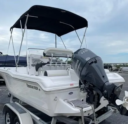 Slide: The Image of 2024 Tidewater 180 CC Adventure boat with outboard motor and canopy on trailer. - 13