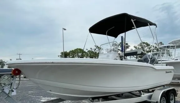 Slide: The Image of 2024 Tidewater 180 CC Adventure boat on trailer with canopy, parked outdoors. - 19
