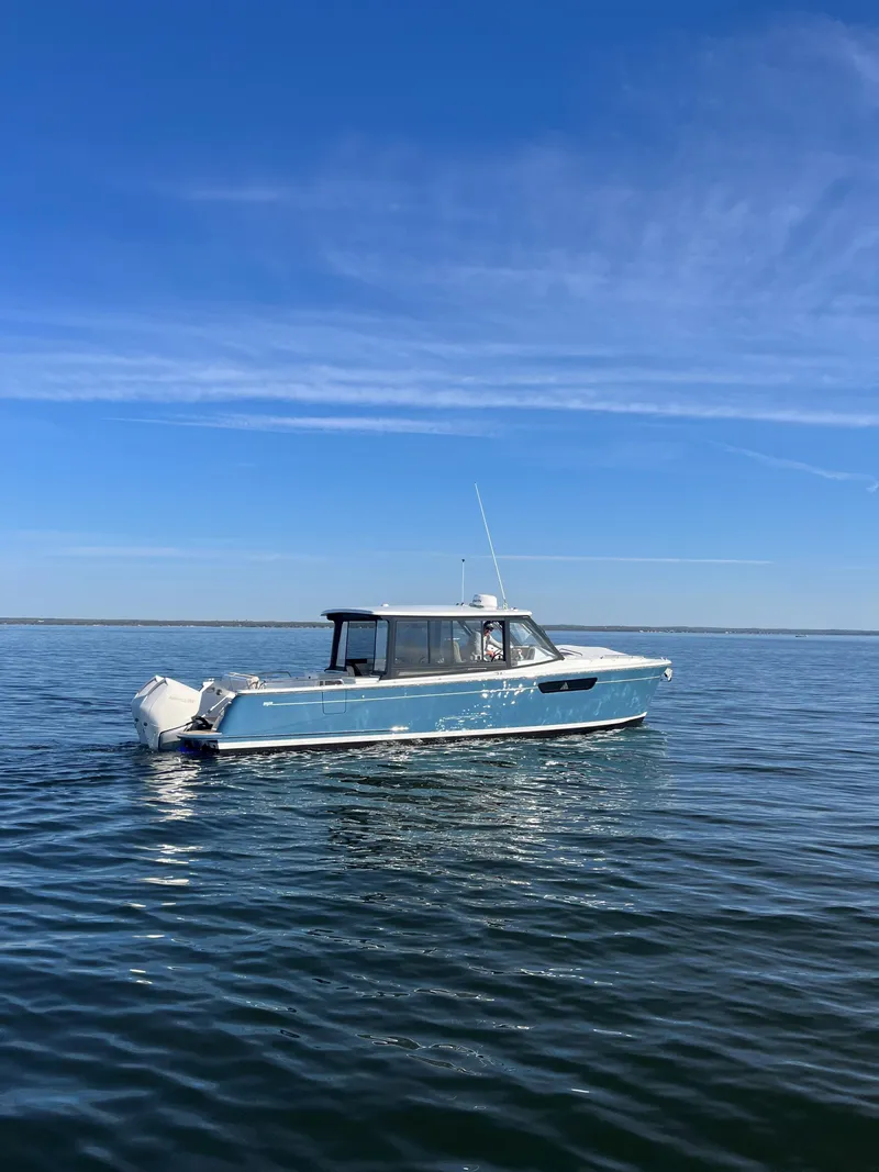Slide: The Image of 2025 MJM 3 boat cruising on calm blue waters under a clear sky. - 0