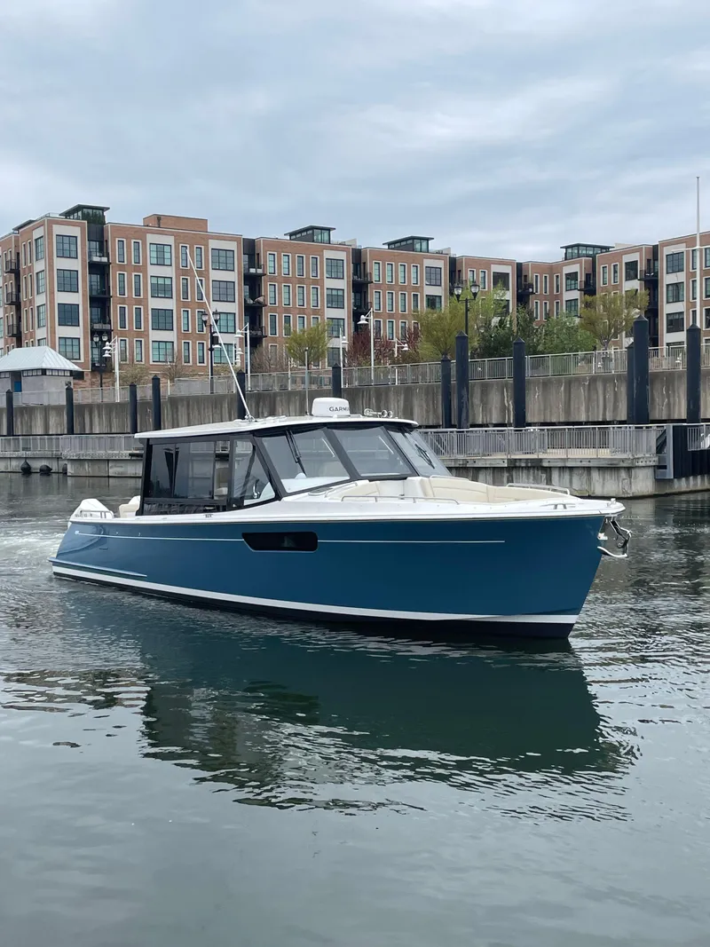 Slide: The Image of 2025 MJM 3 boat cruising in urban waterfront setting. - 1