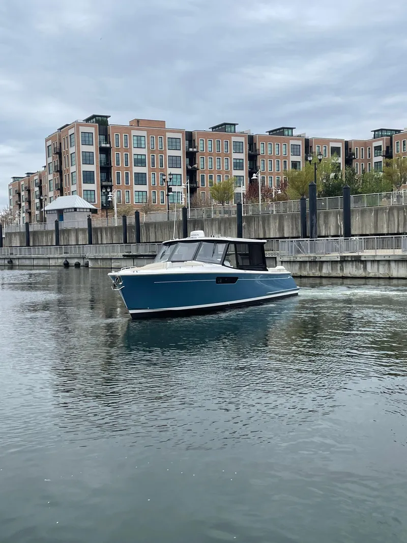 Slide: The Image of 2025 MJM 3 boat cruising in urban waterfront setting with modern buildings. - 10