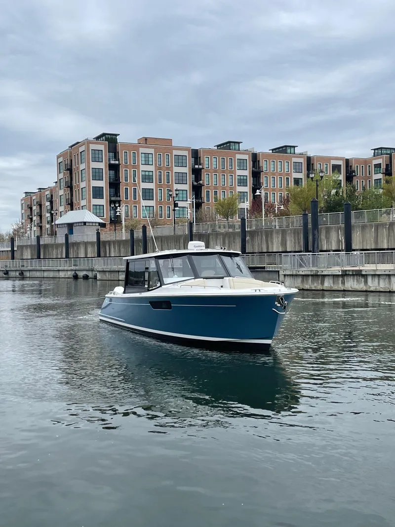 Slide: The Image of 2025 MJM 3 boat cruising in urban waterfront with modern buildings. - 12