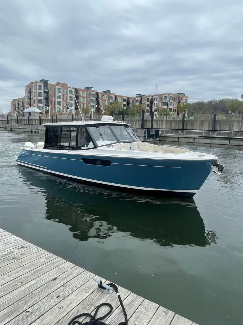 Slide: The Image of 2025 MJM 3 boat docked in a marina with modern buildings in the background. - 14