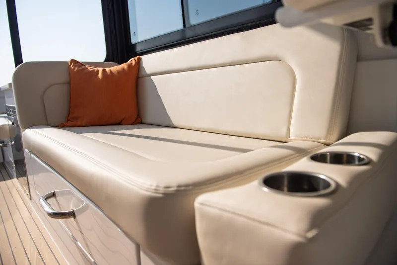 Slide: The Image of Luxurious seating on 2025 MJM 3 boat with orange cushion and cup holders. - 25