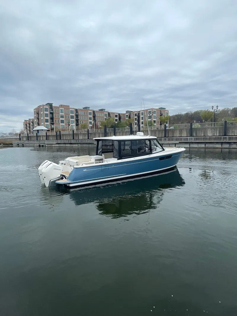 Slide: The Image of 2025 MJM 3 boat on calm water near modern waterfront buildings. - 3