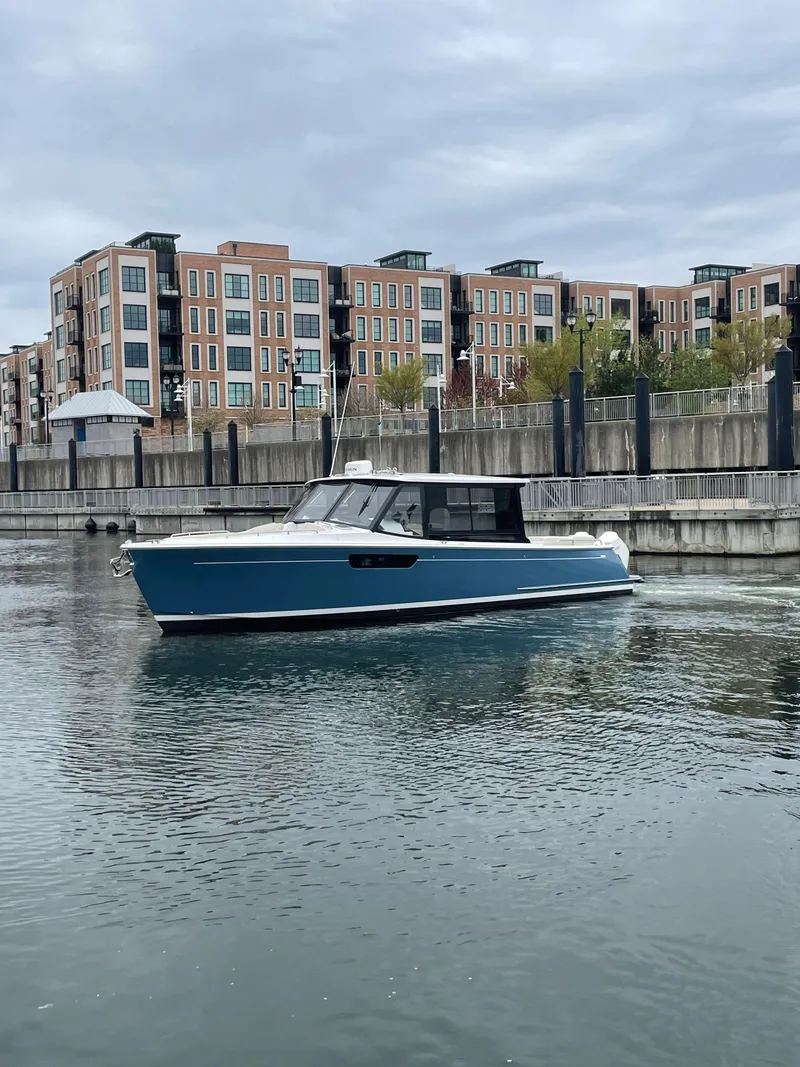 Slide: The Image of 2025 MJM 3 boat on calm water near modern buildings. - 9