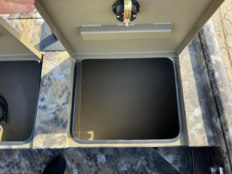 Slide: The Image of Open storage compartment in 2025 Excel Eclipse boat, featuring camo-patterned flooring. - 10