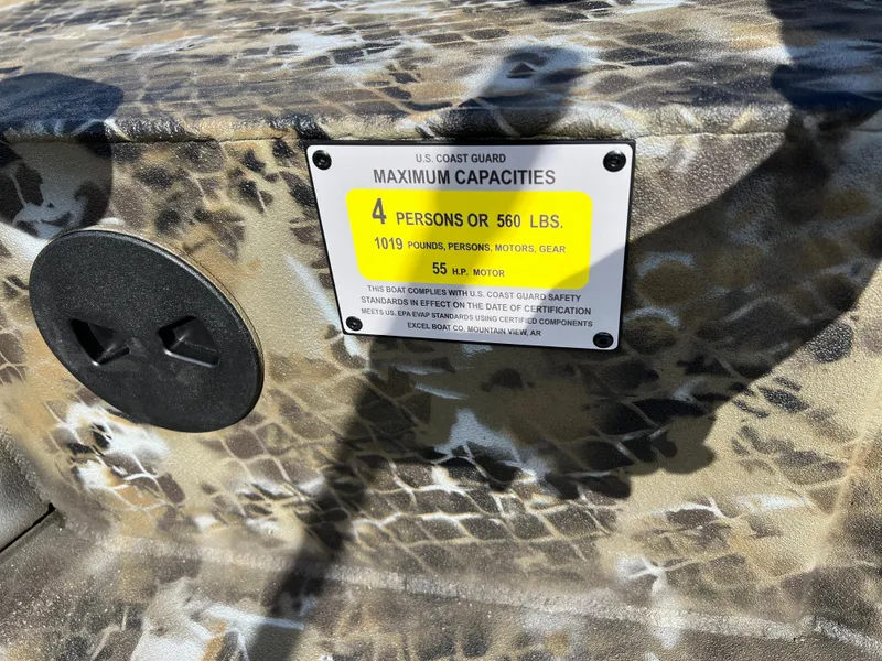Slide: The Image of Boat capacity label on camo surface, Excel Eclipse 2025, max 4 persons or 560 lbs. - 17