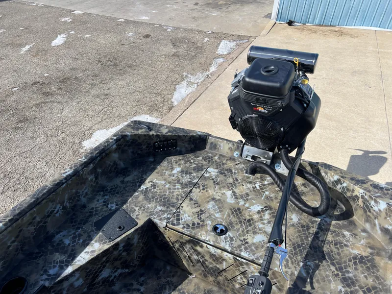 Slide: The Image of 2025 Excel Eclipse boat with camouflage design and motor, parked on concrete. - 18