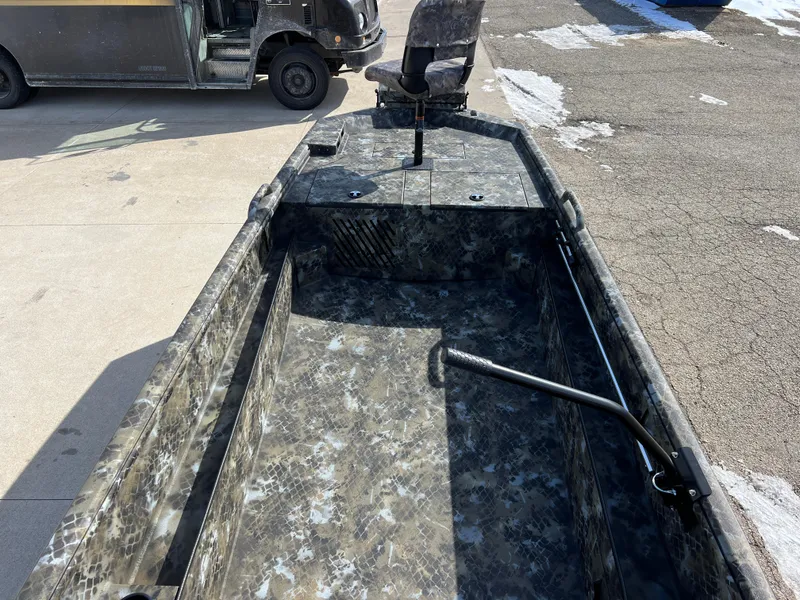 Slide: The Image of 2025 Excel Eclipse boat with camouflage interior, parked near a delivery truck. - 21