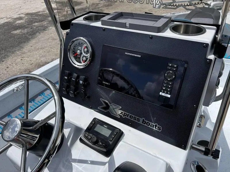 Slide: The Image of 2025 Xpress H20B boat dashboard with steering wheel and electronic controls. - 13
