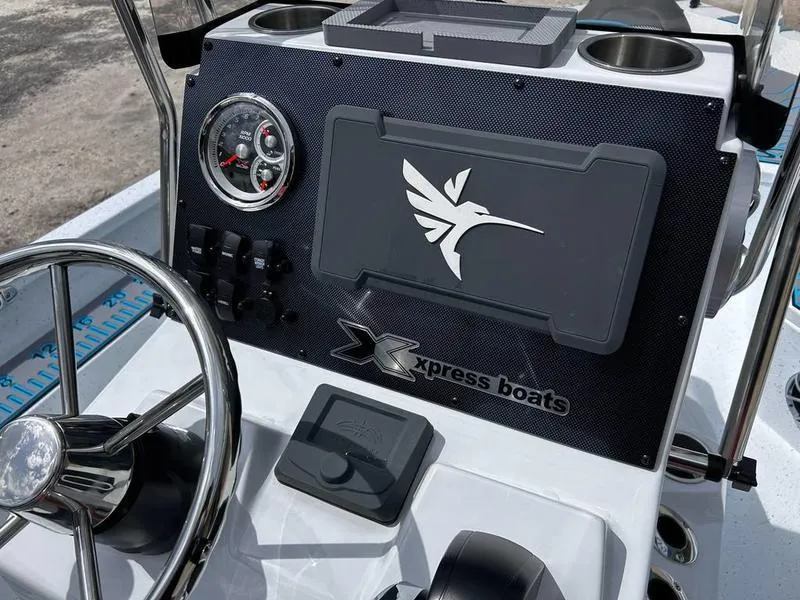 Slide: The Image of 2025 Xpress H20B boat dashboard with steering wheel, gauges, and logo. - 14