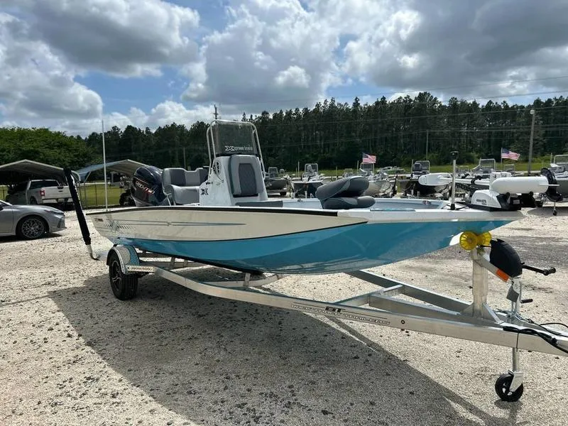 Slide: The Image of 2025 Xpress H20B boat on trailer under cloudy sky, surrounded by other boats. - 5