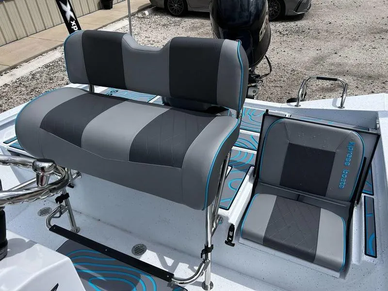 Slide: The Image of 2025 Xpress H20B boat seats, gray and black with blue accents, on a clean deck. - 9