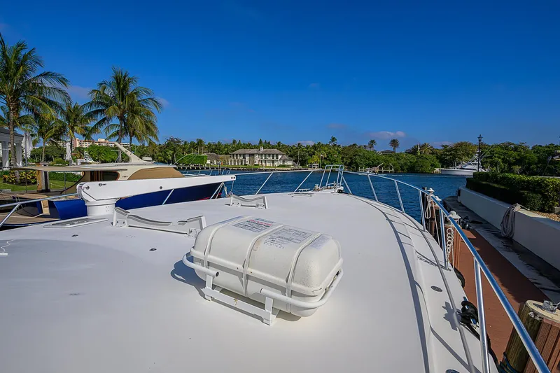 Slide: The Image of 2007 Viking 68 Convertible yacht deck with scenic waterfront view and palm trees. - 15