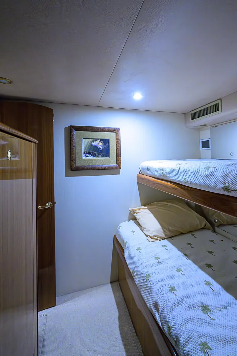 Slide: The Image of 2007 Viking 68 Convertible yacht cabin with bunk beds and framed artwork. - 24