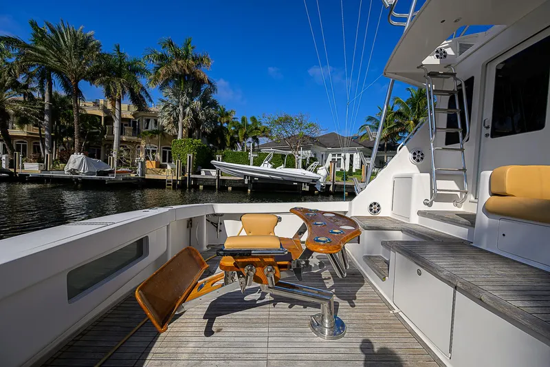 Slide: The Image of 2007 Viking 68 Convertible yacht deck with fishing chair, docked by palm trees. - 29