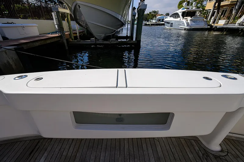Slide: The Image of 2007 Viking 68 Convertible yacht docked, showcasing rear deck and water view. - 32