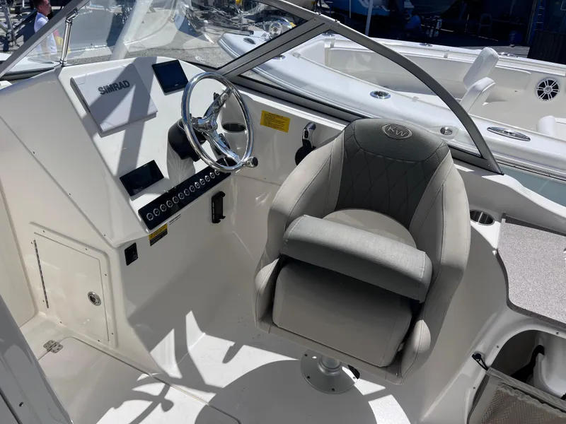 Slide: The Image of 2025 Key West 239 DFS boat cockpit with steering wheel and cushioned seat. - 16