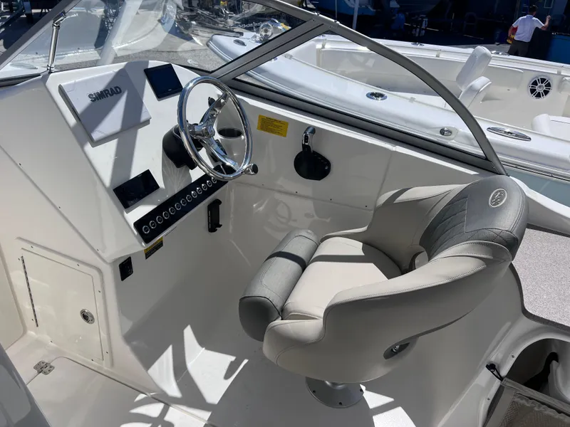 Slide: The Image of 2025 Key West 239 DFS boat cockpit with steering wheel and comfortable seating. - 17