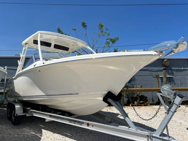 Slide: The Image of 2025 Key West 239 DFS boat on trailer, displayed outdoors under clear blue sky. - 2