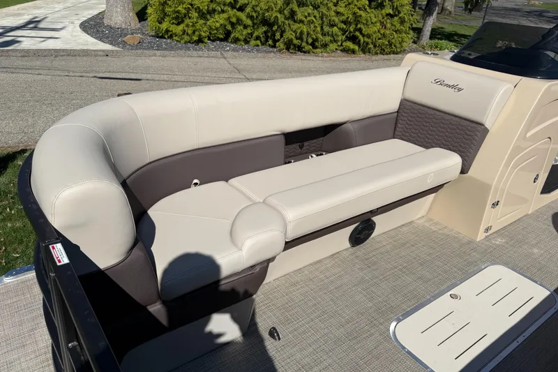 Slide: The Image of 2025 Bentley Pontoons Elite 253 Admiral interior with beige and brown seating. - 12