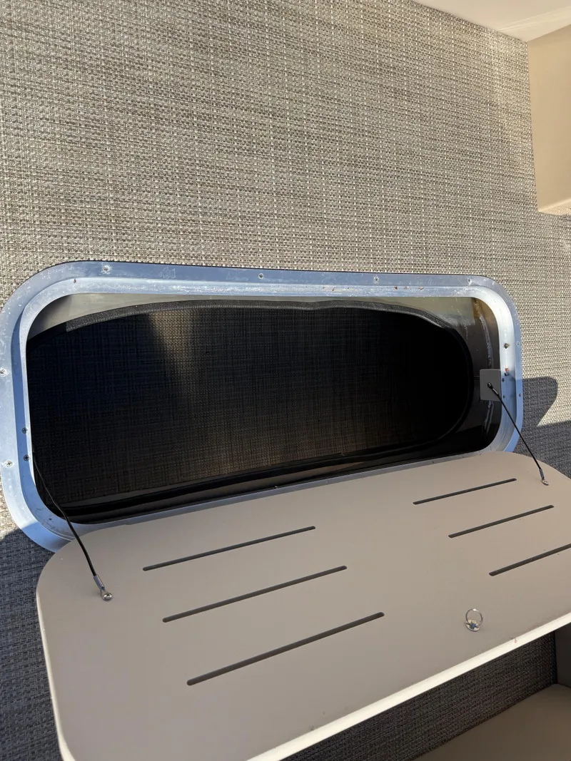 Slide: The Image of 2025 Bentley Pontoons Elite 253 Admiral storage compartment with open hatch. - 17