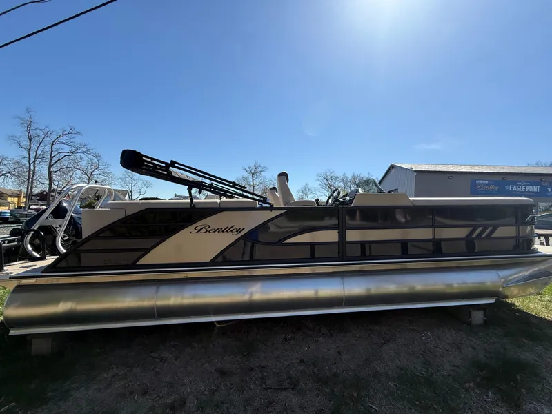 Slide: The Image of 2025 Bentley Pontoons Elite 253 Admiral pontoon boat under clear blue sky. - 2