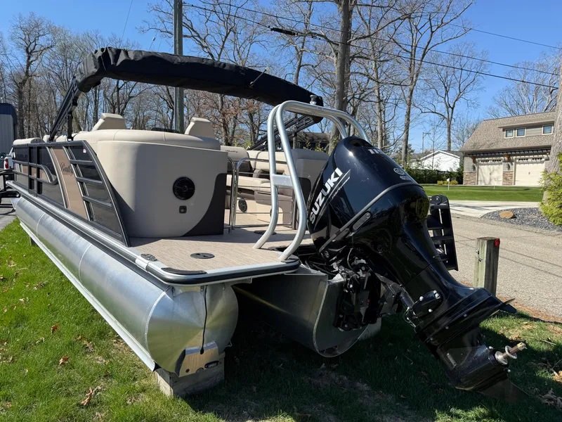 Slide: The Image of 2025 Bentley Pontoons Elite 253 Admiral with Suzuki outboard motor, parked on grass. - 6