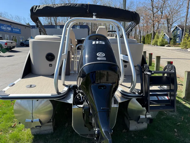 Slide: The Image of 2025 Bentley Pontoons Elite 253 Admiral with powerful outboard motor, parked on grass. - 7