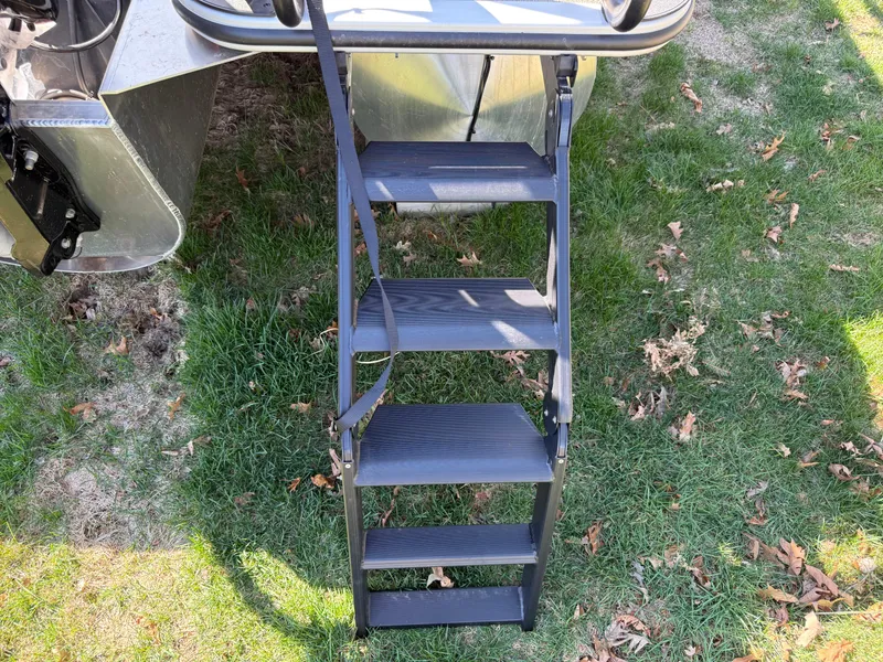 Slide: The Image of Sturdy ladder on 2025 Bentley Pontoons Elite 253 Admiral, set on grassy ground. - 9