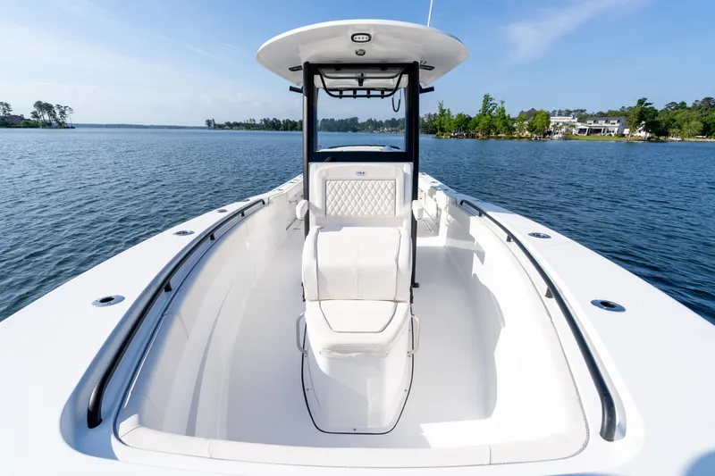 Slide: The Image of 2026 Sea Hunt Gamefish 27 Coffin Box boat on calm water, featuring sleek design and spacious deck. - 38