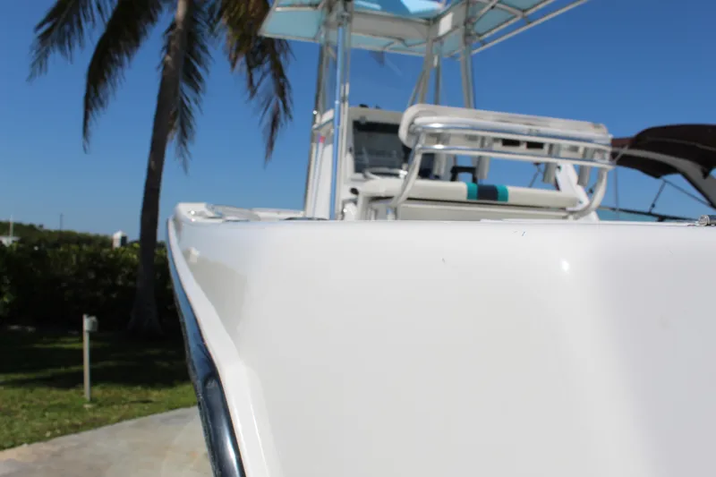 Slide: The Image of 2002 Contender 31 CC boat with sleek design, palm trees in background. - 16