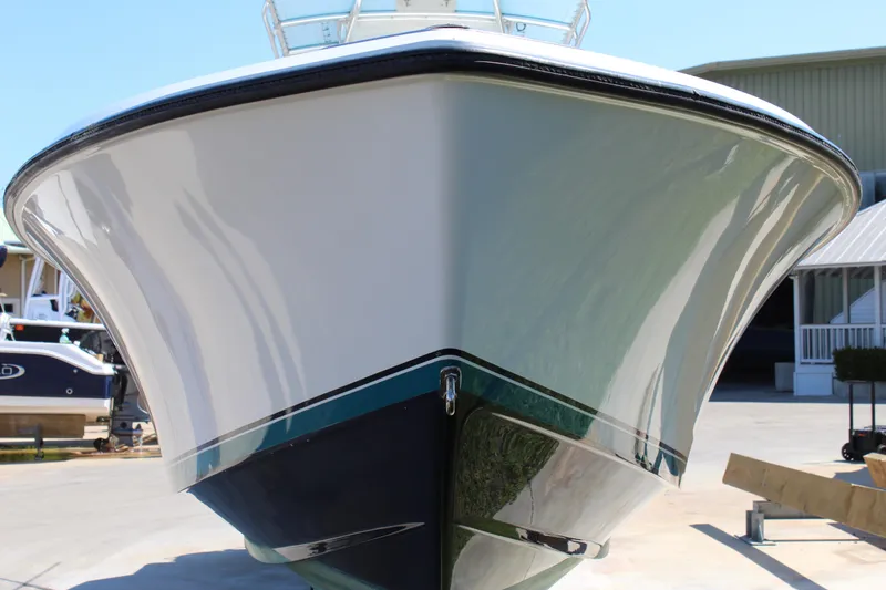 Slide: The Image of 2002 Contender 31 CC boat, front view, docked outdoors on a sunny day. - 2