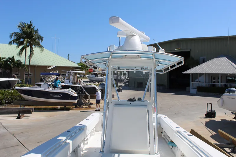Slide: The Image of 2002 Contender 31 CC boat at a marina, surrounded by other vessels and buildings. - 23