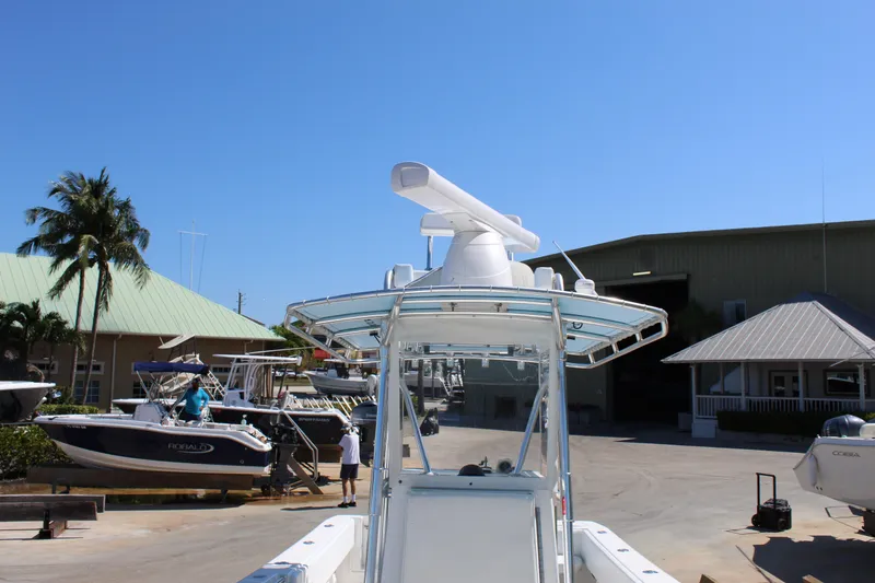 Slide: The Image of 2002 Contender 31 CC boat at a marina with clear blue sky. - 24