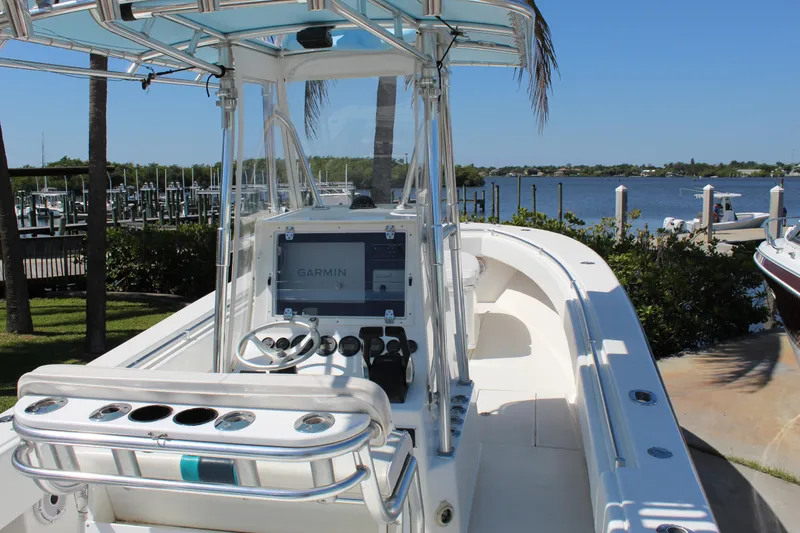 Slide: The Image of 2002 Contender 31 CC boat with center console, docked by a scenic waterfront. - 32