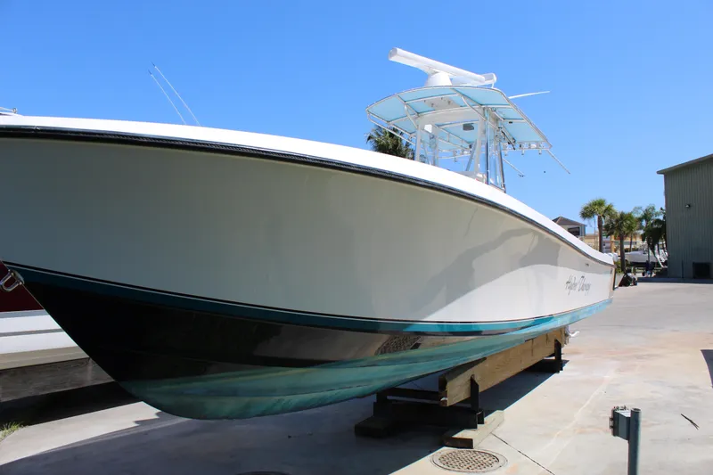 Slide: The Image of 2002 Contender 31 CC boat on dry dock, white hull, clear blue sky background. - 38