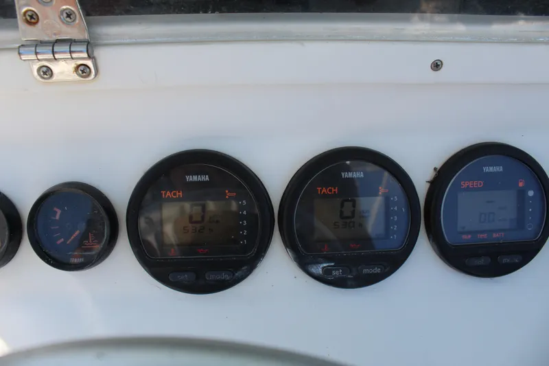 Slide: The Image of Dashboard gauges of a 2002 Contender 31 CC boat, featuring Yamaha tachometers and speedometer. - 47