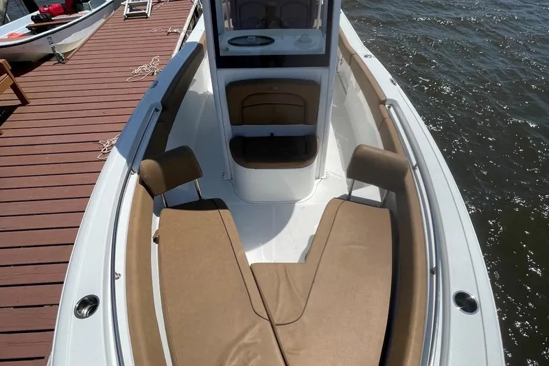 Slide: The Image of 2021 Sea Hunt 239 Ultra SE boat with tan seating, docked by the water. - 13