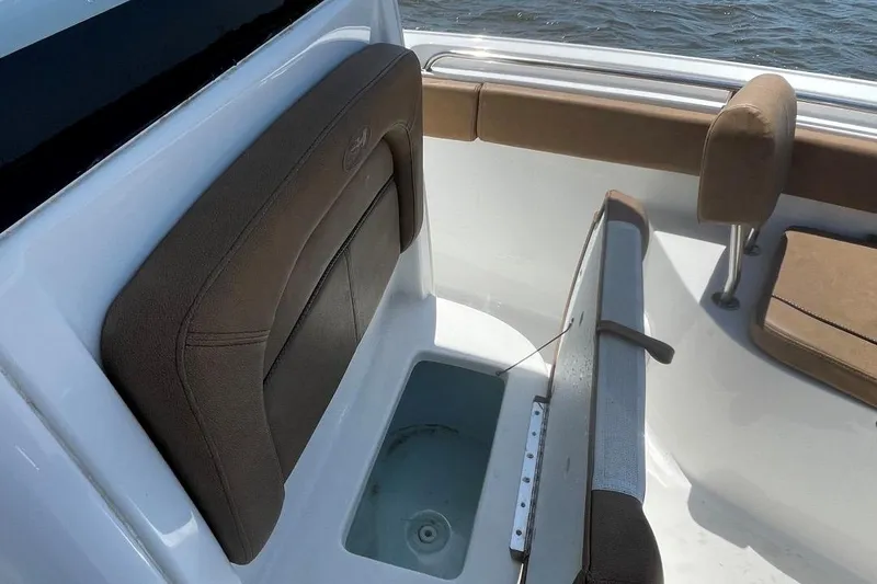 Slide: The Image of 2021 Sea Hunt 239 Ultra SE boat interior with cushioned seating and storage compartment. - 15