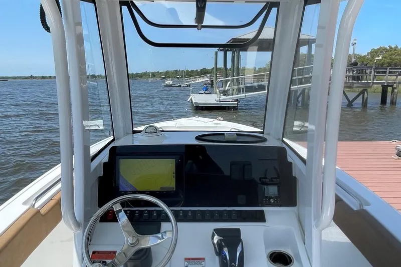Slide: The Image of 2021 Sea Hunt 239 Ultra SE boat dashboard with steering wheel and navigation screen. - 19