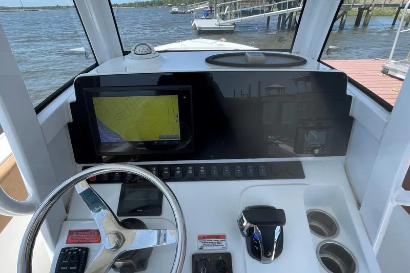 Slide: The Image of 2021 Sea Hunt 239 Ultra SE boat dashboard with navigation screen and steering wheel. - 21