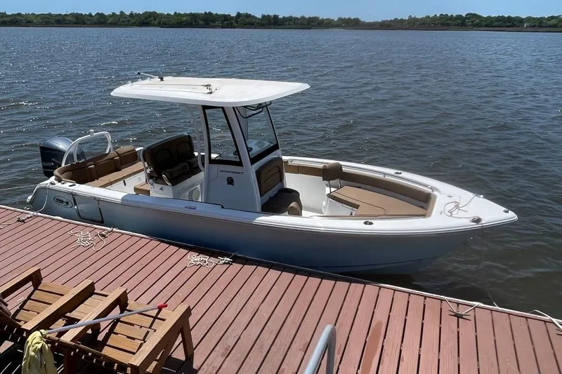 Slide: The Image of 2021 Sea Hunt 239 Ultra SE boat docked on a calm lake. - 5