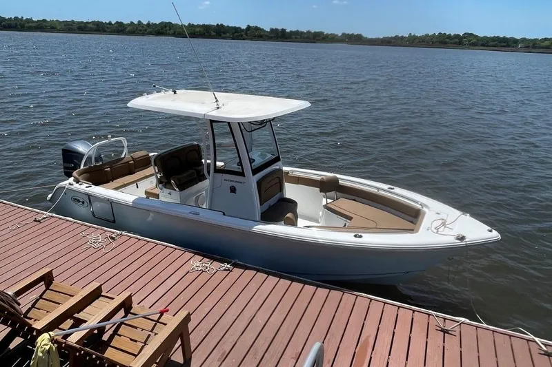 Slide: The Image of 2021 Sea Hunt 239 Ultra SE boat docked on a sunny day by the water. - 6